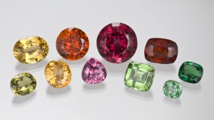 Photographed from the GIA Collection for the CIBJO project. Top row, left to right: 16.94 ct yellow oval garnet; 19.89 ct round orange spessartite garnet; 44.28 ct round, deep pink rhodolite garnet; 16.99 ct reddish orange cushion cut garnet; and 7.26 ct cushion cut tsavorite garnet. Bottom row, left to right: 8.20 ct oval greenish yellow garnet; 12.36 ct oval golden yellow garnet; 9.22 ct pink pear cut garnet; 14.53 ct light green cushion cut grossular garnet and 4.32 ct bluish green cushion cut garnet.